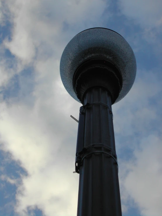 a black pole with two grey balls on top of it