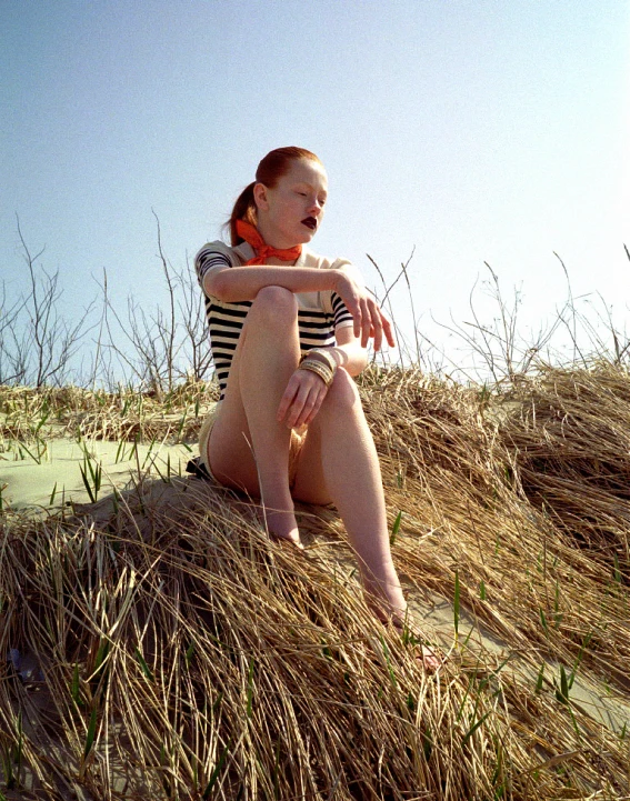 a woman sits on the sand and watches soing