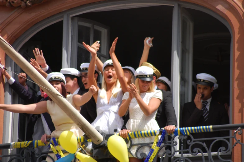 young female sailor cheering in the window of an old building