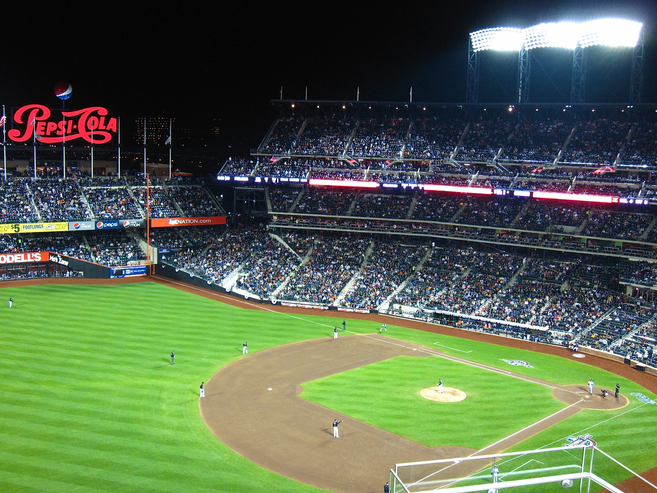 a baseball stadium filled with people at night