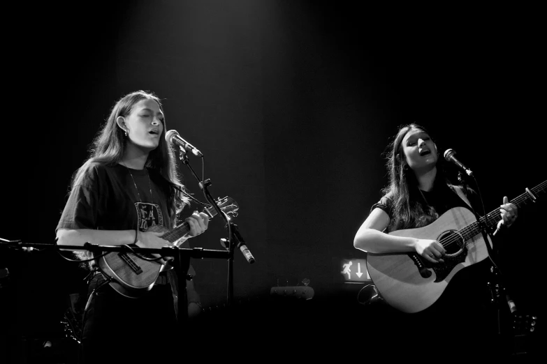 a couple of women playing guitars on stage