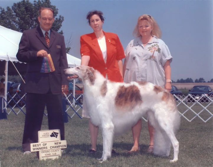 a couple of women standing next to a dog