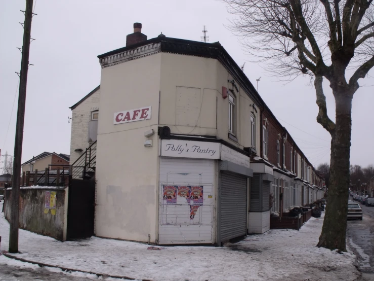 an old building is shown with snow and buildings surrounding it