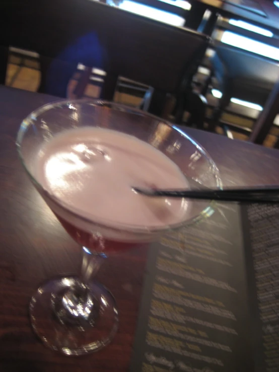 a drink sits in a bowl next to a menu