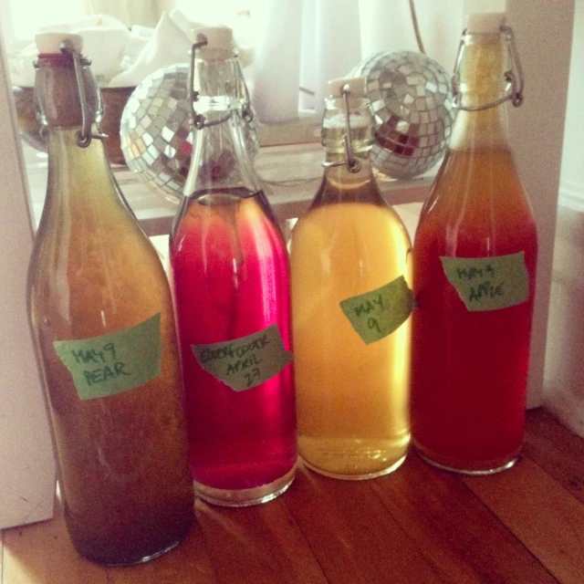 three empty bottles with labels on them sitting in front of a mirror