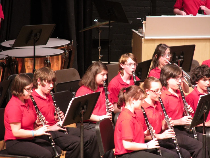 several women in red shirts playing the saxophone