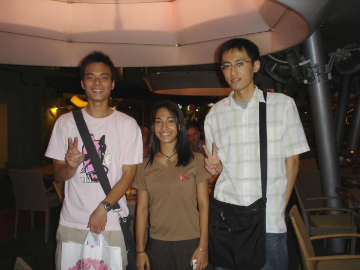 two men and a woman are standing in a restaurant