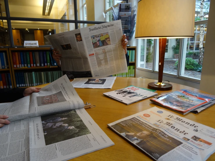 a person is holding out some papers at a table