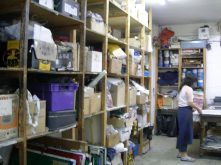 a woman standing in a room filled with wooden shelves