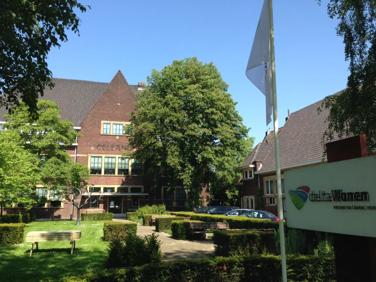 a flag is flying outside a school that's next to a building