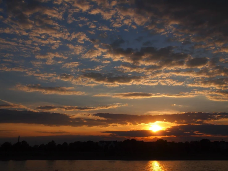 there is a very dark picture with the sun setting behind the clouds