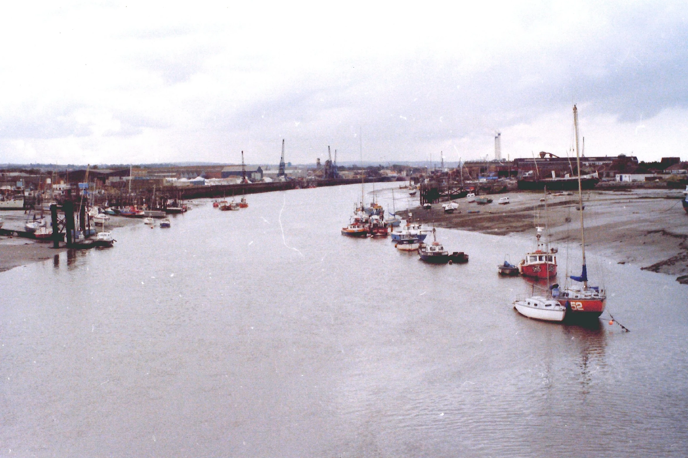 a river with several boats on it and houses