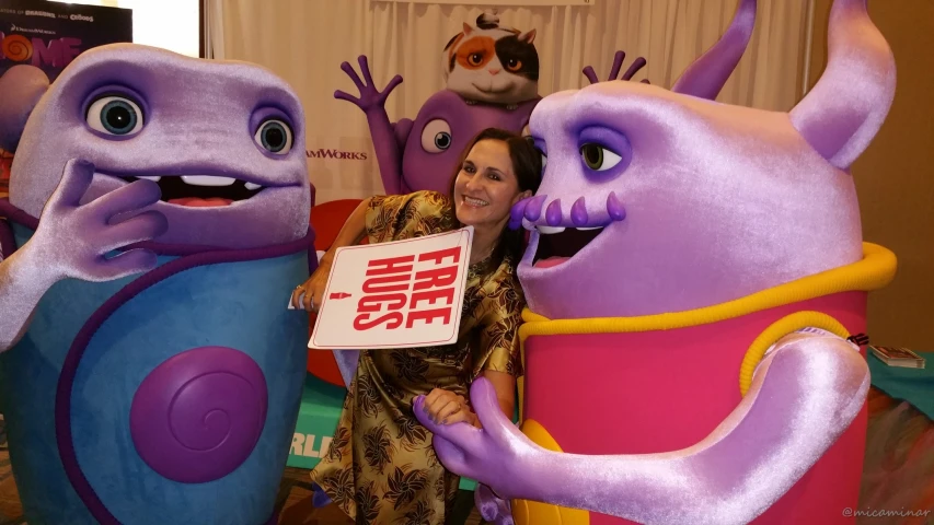a woman is standing between some large purple characters