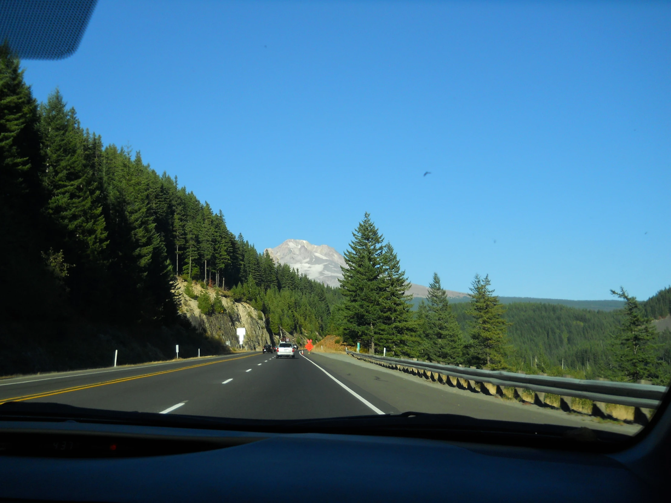 there is a view out of the front window of a car driving through a scenic area with trees