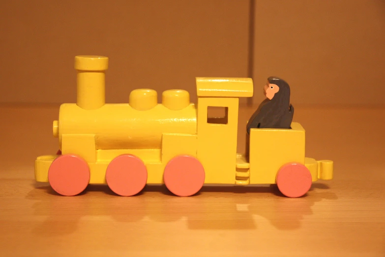 toy train with figure on side and orange train car