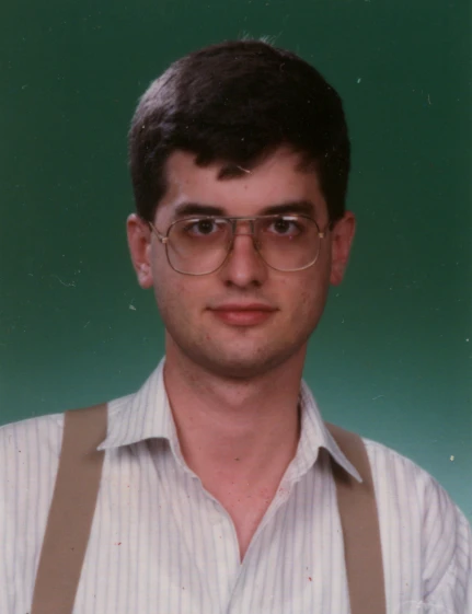 a man with glasses, suspenders and a striped shirt