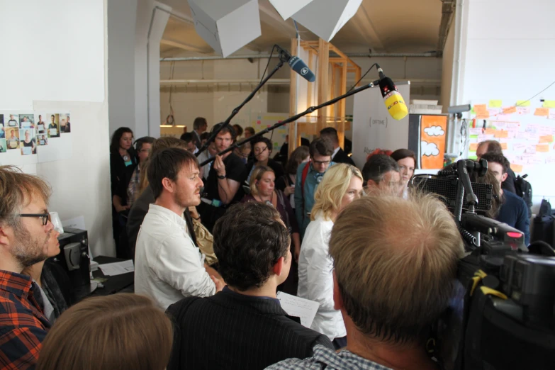 a crowd of people sitting and standing around in a room