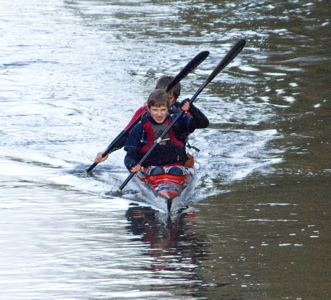 two people on kayaks paddle through the water