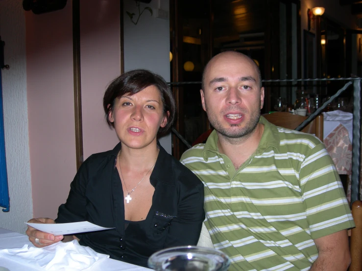 a man and woman are sitting next to each other at a table
