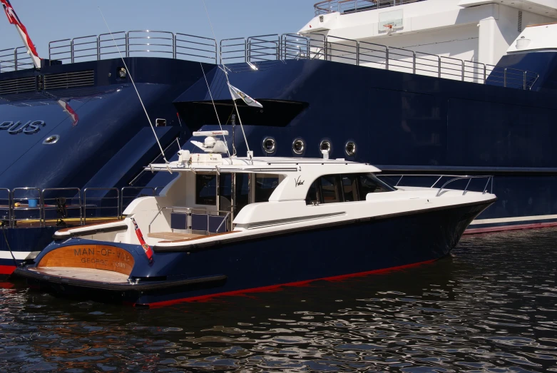 a large blue ship sits next to another boat