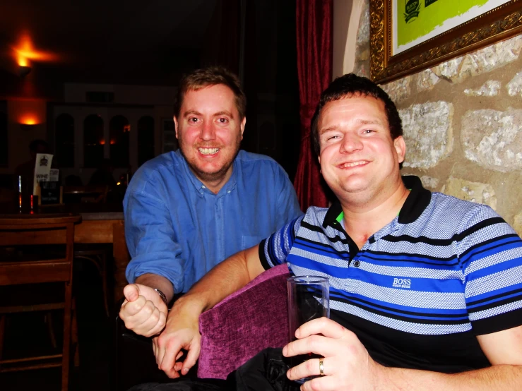 two men sitting in a chair at the same time