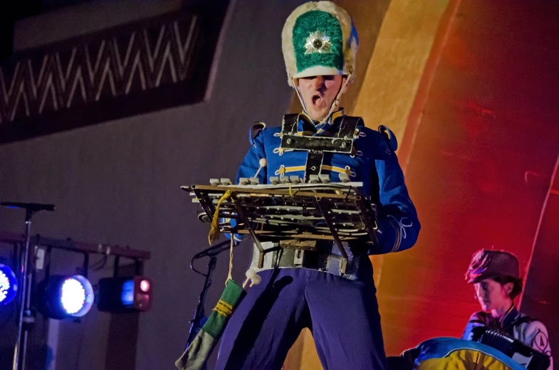 a person wearing uniform playing with a musical instrument on stage