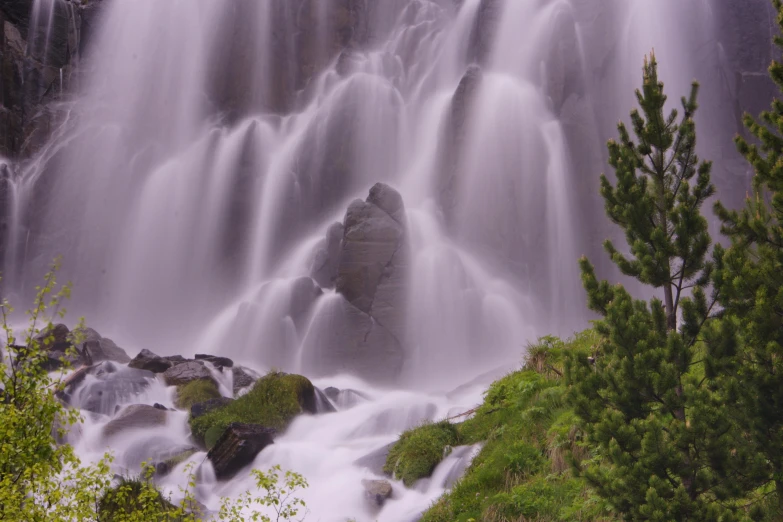 a waterfall is shown surrounded by green trees