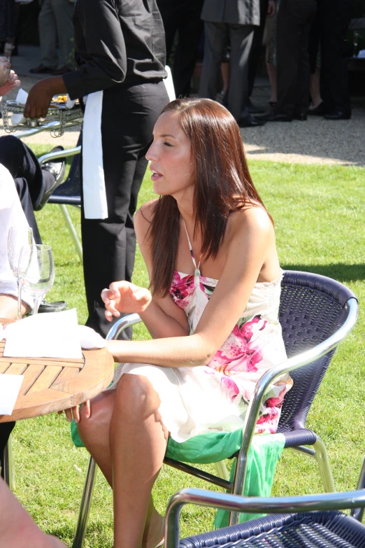 a woman in white dress sitting at an outdoor table