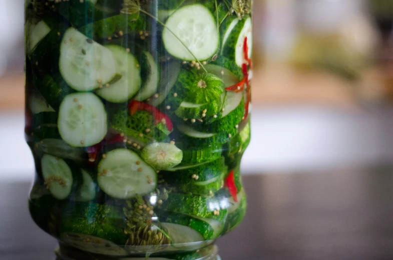 a close up of a glass jar with vegetables in it