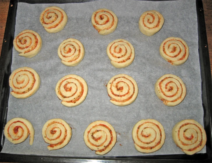 some cinnamon rolls on a sheet of baking paper