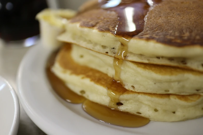 four pancakes are sitting on a plate topped with syrup