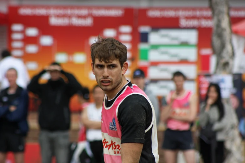 the young man is wearing a pink and black outfit