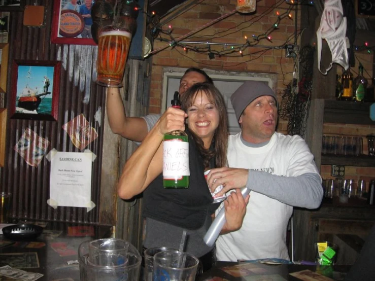 people standing around at the bar with beer