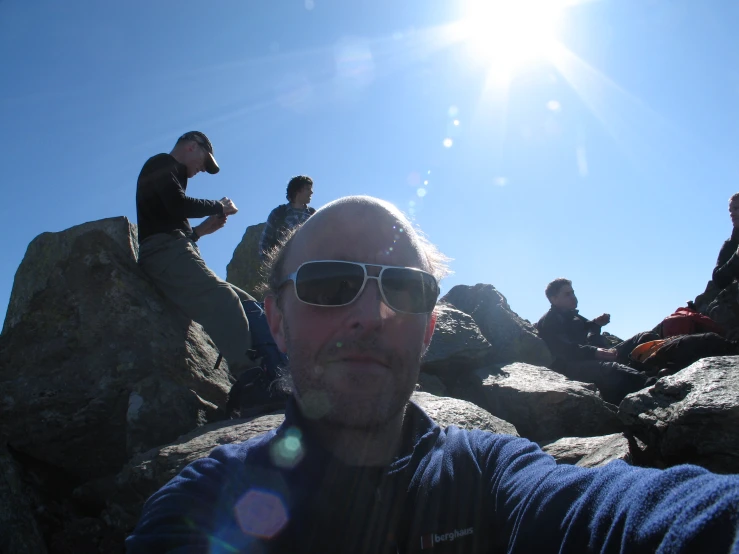 a group of people are sitting on some rocks