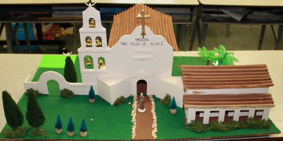 a model white house on a table with a walkway going to it