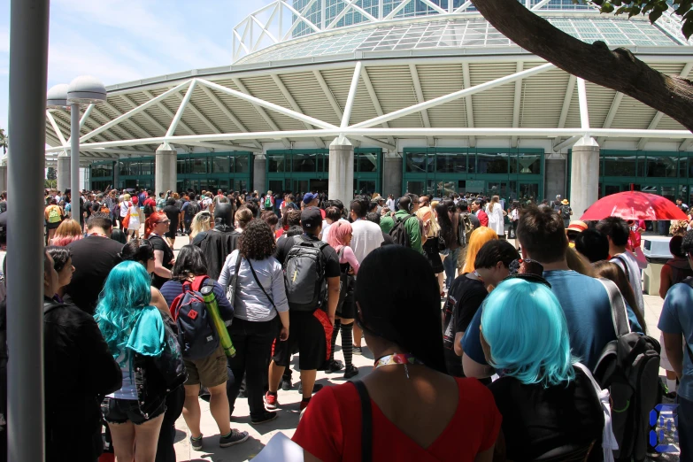 a crowd of people standing in a large building