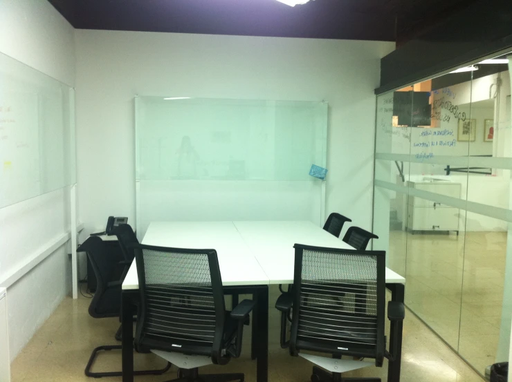 an empty conference room with a desk and a large glass divider