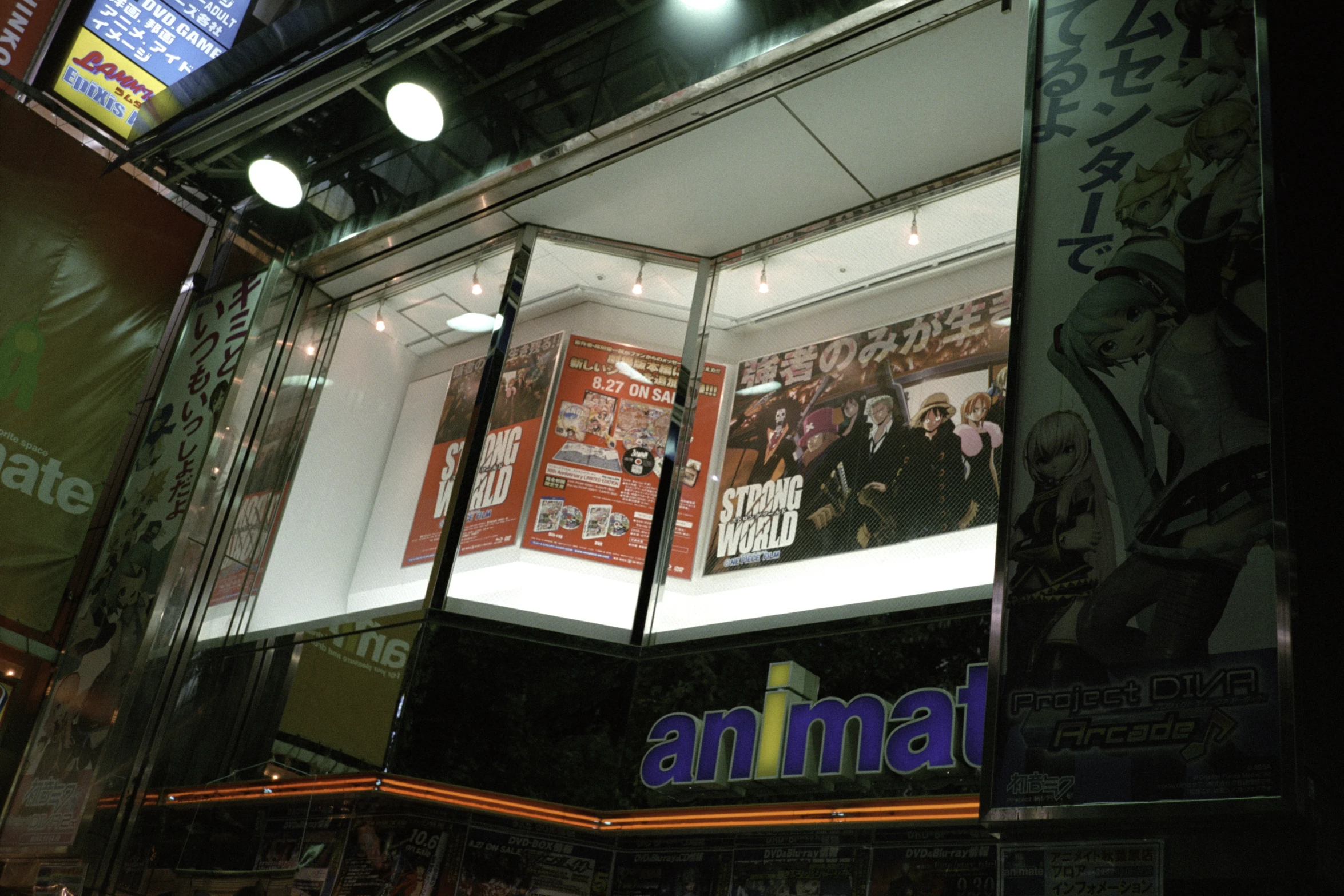 a lighted shop front with posters and neon lights