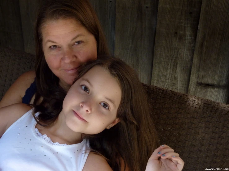 a woman hugging her daughter on the couch