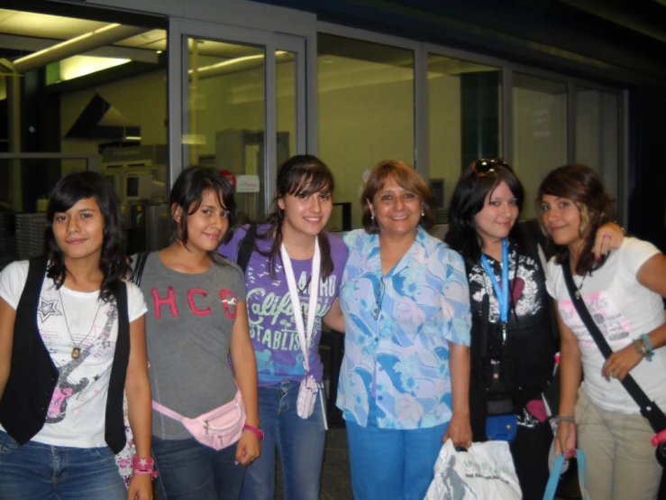 six young ladies pose in front of a building