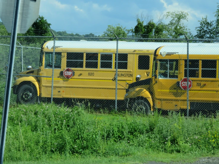 an old school bus parked behind a fence