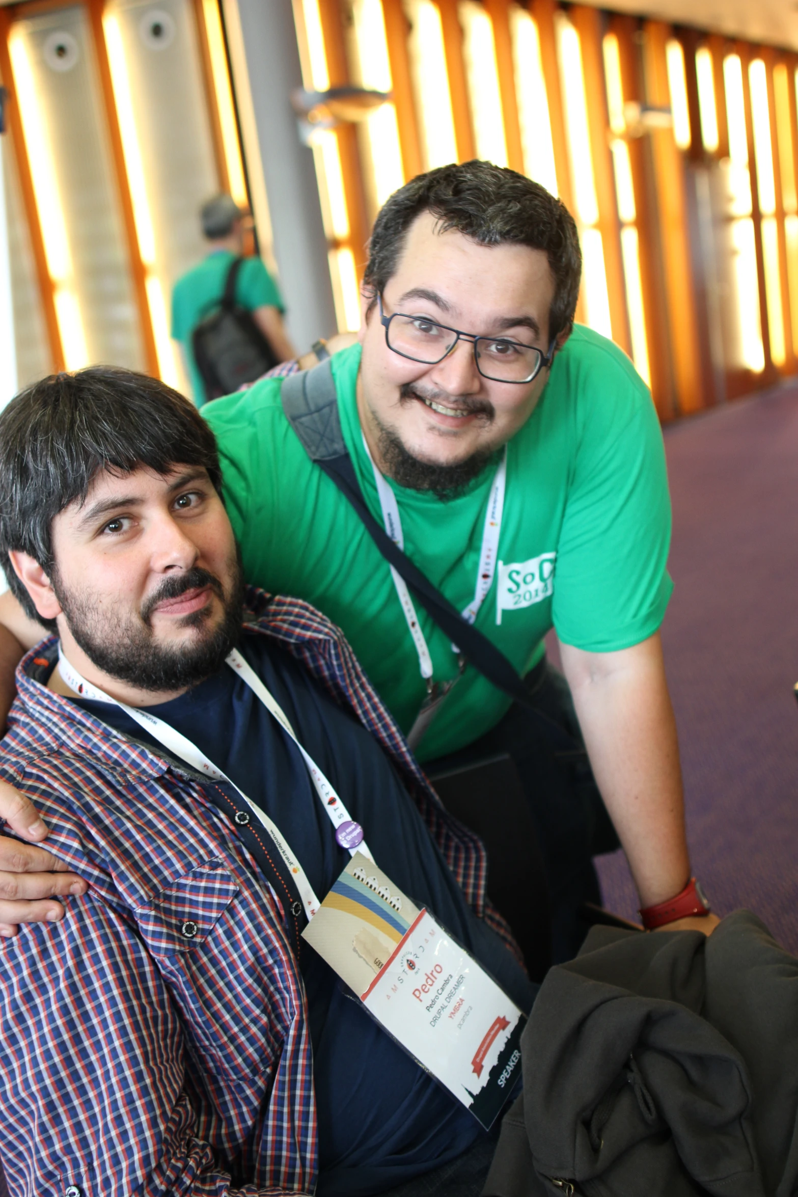 two men are wearing green shirts and posing for a picture