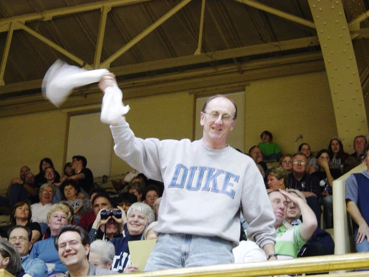 a man standing in front of a crowd with paper