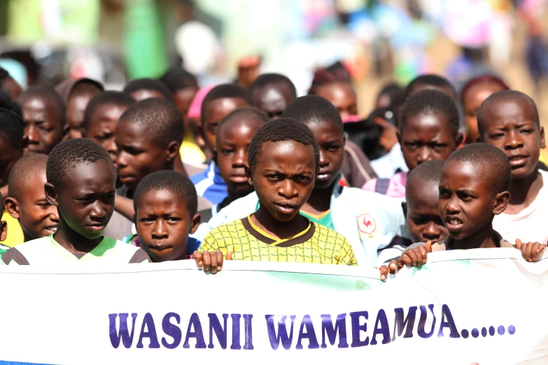 a group of children with a sign in front of them