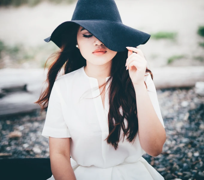 a girl wearing a black hat with her hair in long wavy bangs