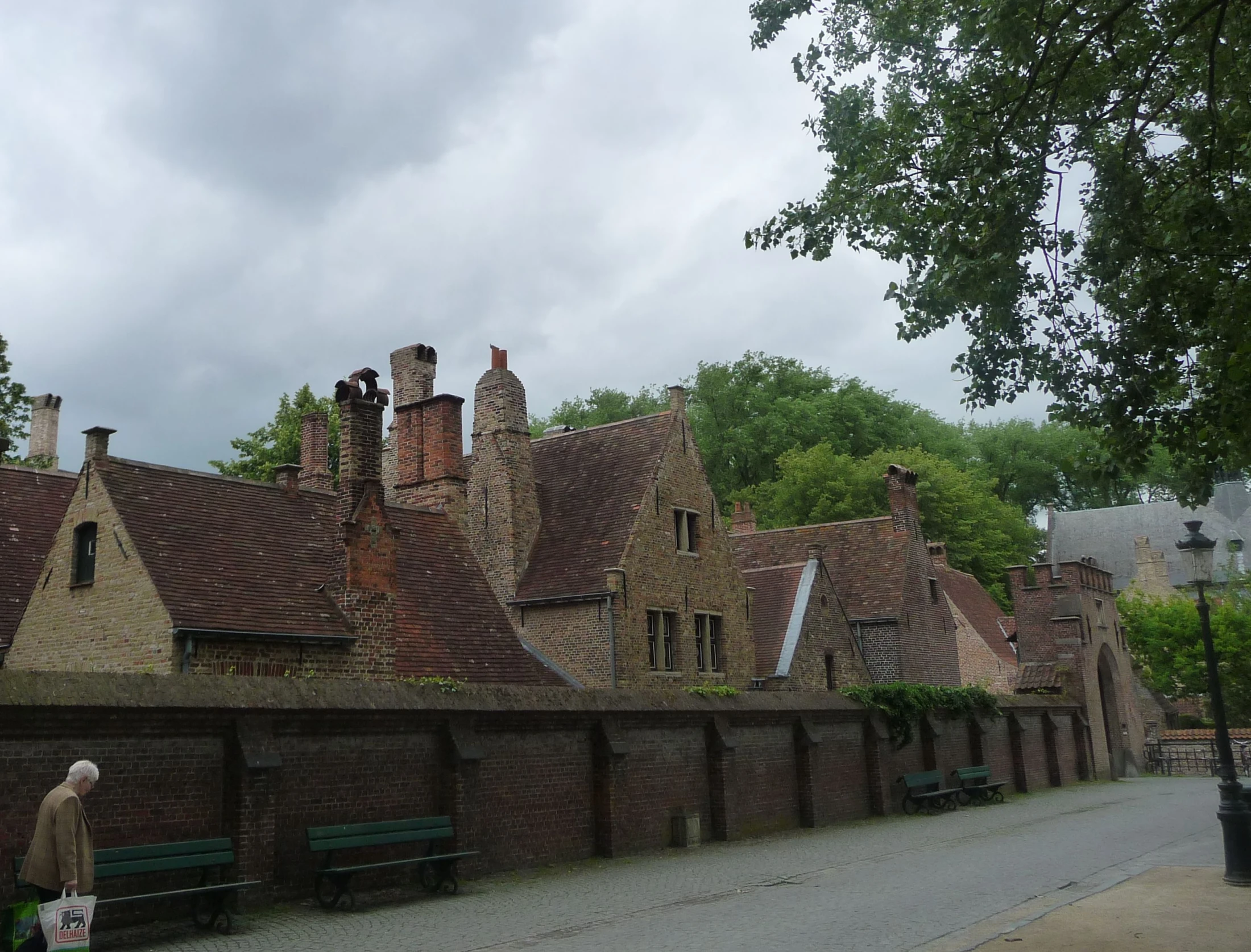 a few benches sitting beside a tall brick wall