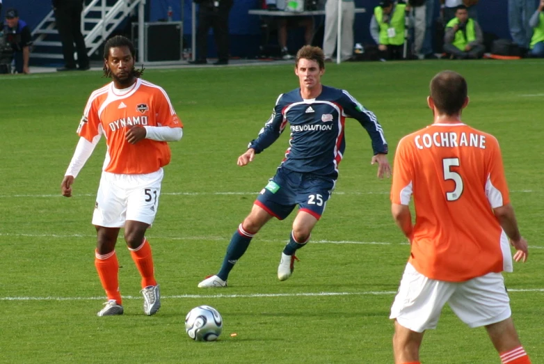 a couple of men playing a game of soccer on top of a field