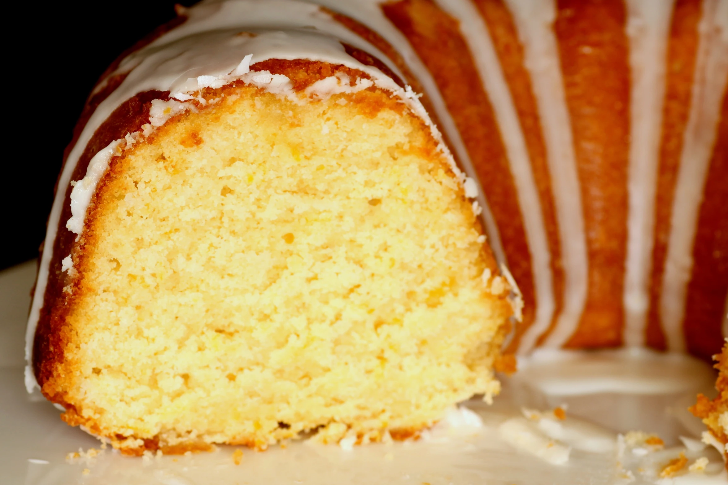 a cake with cream cheese on top of it is next to a striped pillow