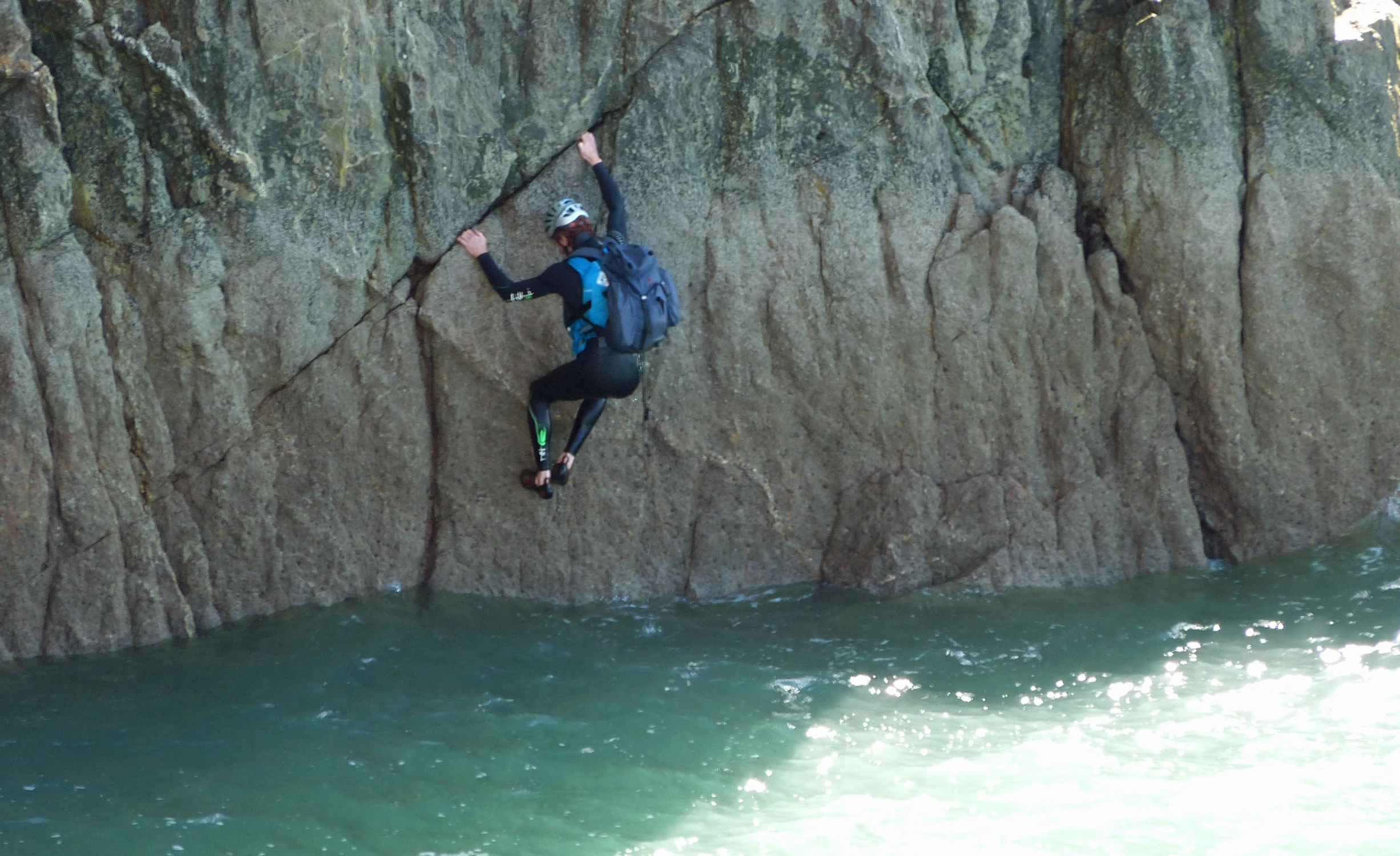 a person wearing a blue jacket doing a rock climb