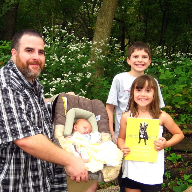 a man is holding up a paper with two children on it